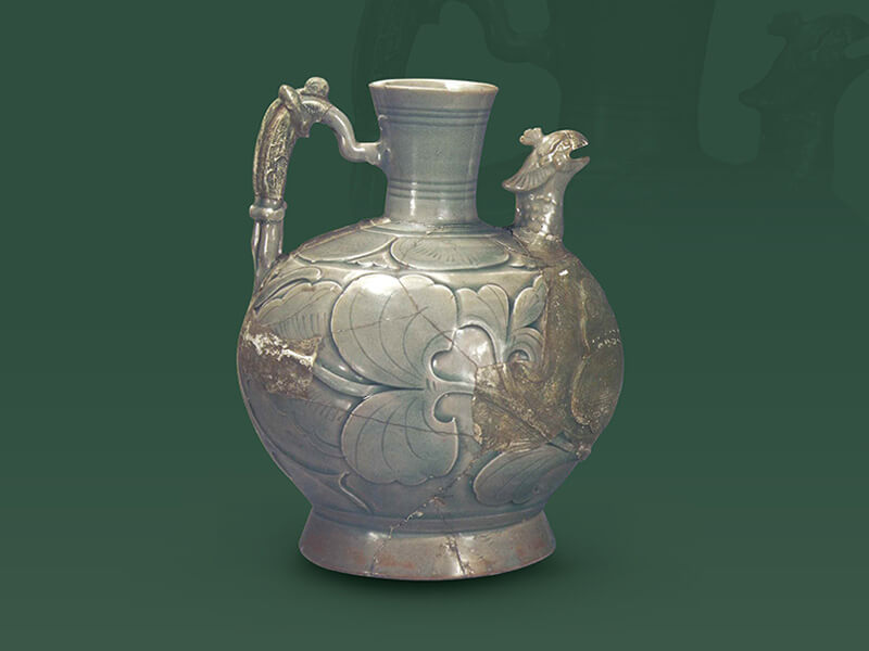 五代—北宋．耀州窯剔劃花鳳首執(zhí)壺+釉色青綠泛藍，腹壁深刻淺浮雕花卉的輪廓，內(nèi)部淺刻葉脈紋理，立體感頗為突出。（圖一）+圖片來源：《中國出土瓷器全集15陜西》，頁114，圖114。