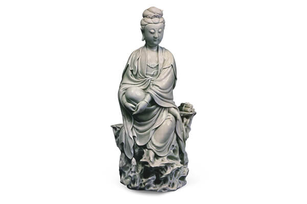 明末+德化窯．白瓷觀音半跏坐像+此尊造像面容慈悲，法相莊嚴，表面施白釉，釉色潤澤如玉，+是德化窯的代表作品。（圖三）+圖片來源：《世界陶磁全集15清》，頁120，圖129。
